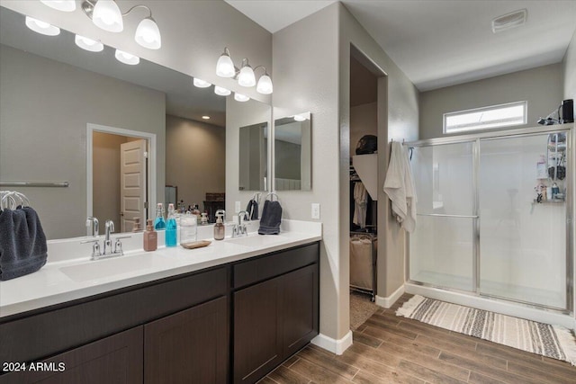 bathroom featuring wood-type flooring, vanity, and walk in shower