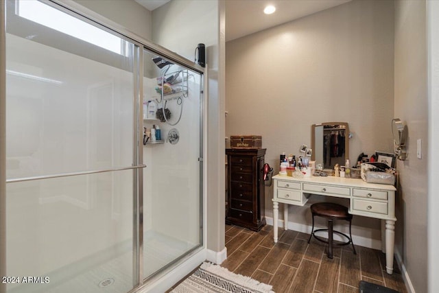 bathroom with a stall shower, vanity, baseboards, and wood tiled floor