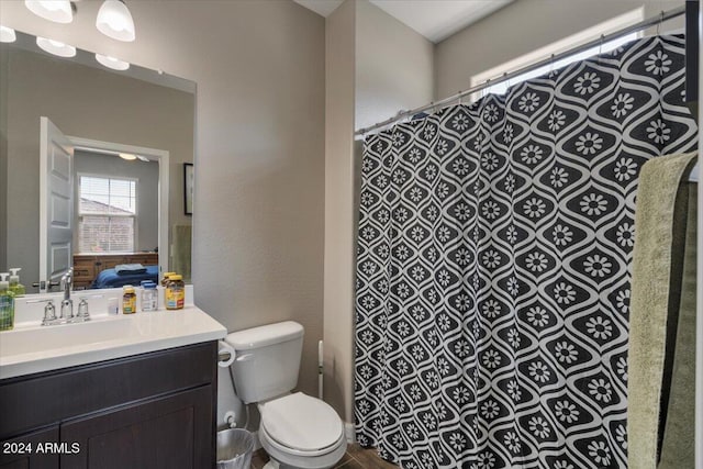 ensuite bathroom featuring curtained shower, vanity, toilet, and ensuite bathroom