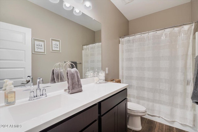 bathroom featuring wood-type flooring, walk in shower, vanity, and toilet