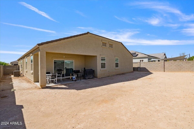 rear view of property with a patio, a fenced backyard, stucco siding, and central AC unit