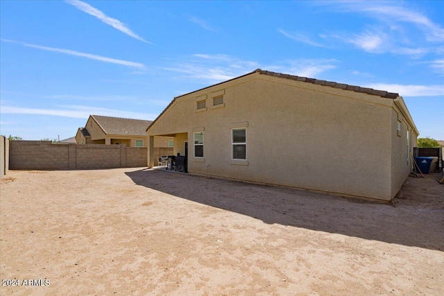 rear view of property featuring a patio area, a fenced backyard, and stucco siding