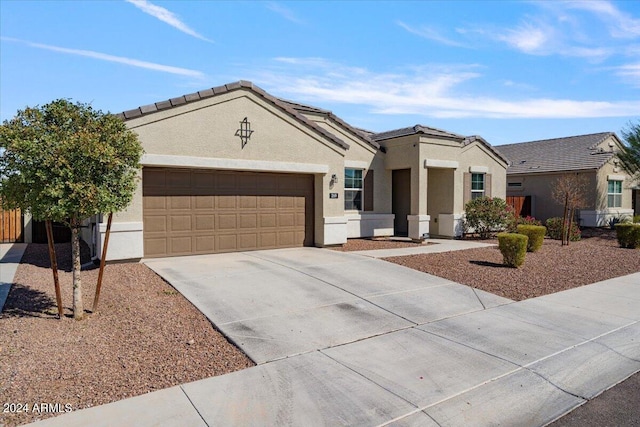 view of front of property with concrete driveway, a garage, and stucco siding