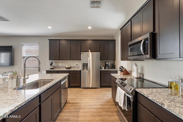 kitchen with stainless steel appliances, light hardwood / wood-style flooring, dark brown cabinetry, and sink