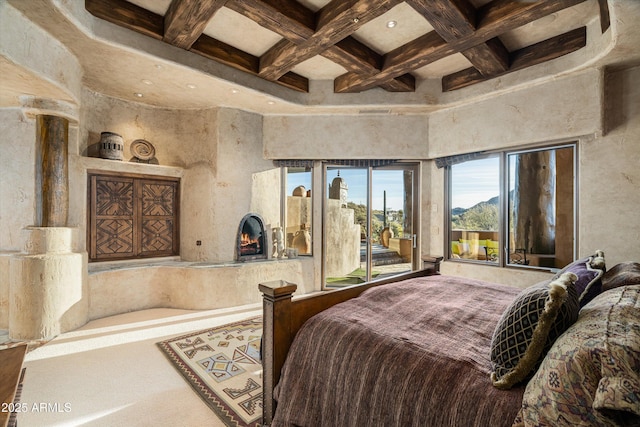 bedroom featuring a high end fireplace, beamed ceiling, and access to outside