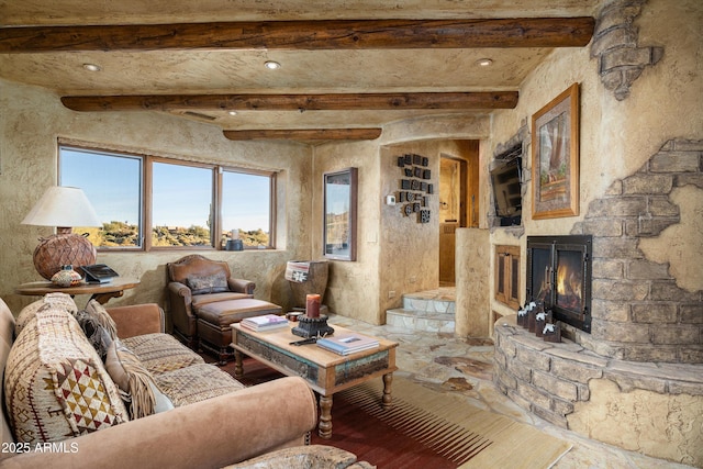 living room with beam ceiling and a fireplace