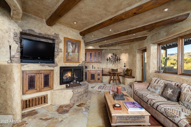 living room with beamed ceiling and a fireplace