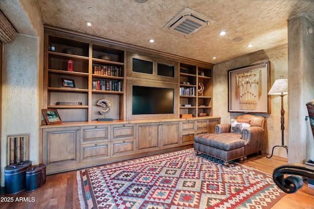 living room with dark hardwood / wood-style flooring and built in shelves