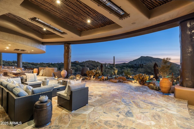 patio terrace at dusk with a mountain view and an outdoor hangout area