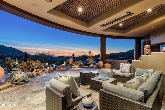 patio terrace at dusk with a mountain view and an outdoor living space with a fire pit