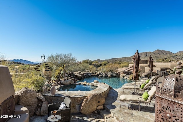 exterior space featuring an in ground hot tub, a mountain view, and a patio area