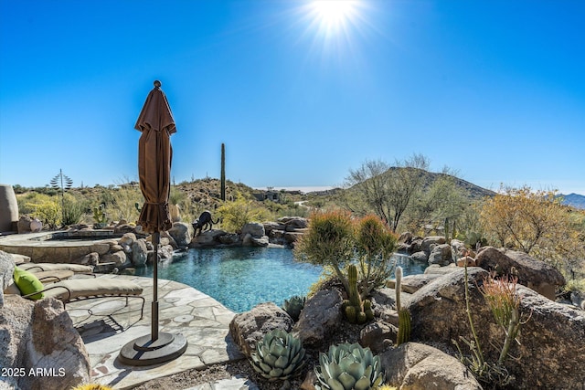 view of swimming pool with a mountain view, a patio, and an in ground hot tub