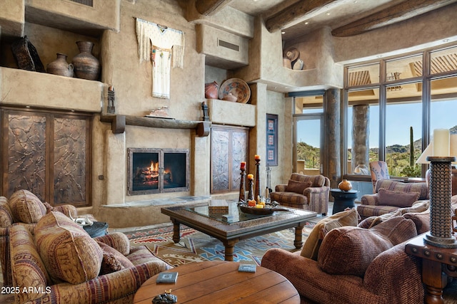 living room featuring a towering ceiling and a high end fireplace