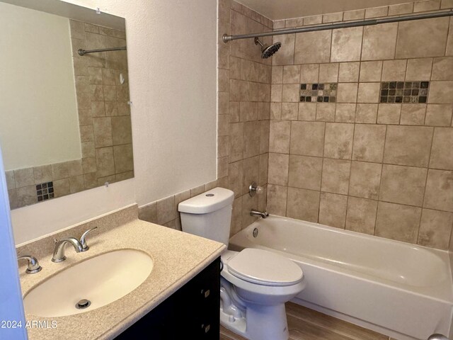 full bath with toilet, vanity, tub / shower combination, and wood finished floors