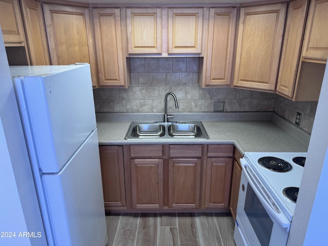 kitchen with white appliances, a sink, light countertops, and tasteful backsplash