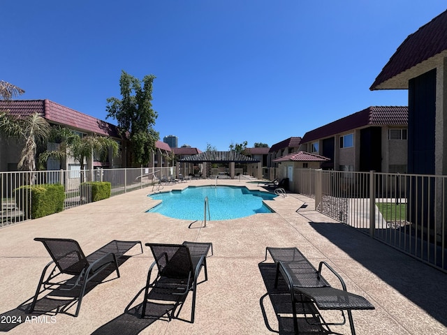 community pool with fence and a patio