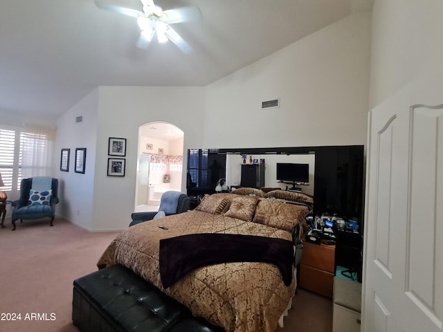 carpeted bedroom featuring ceiling fan, lofted ceiling, and ensuite bath