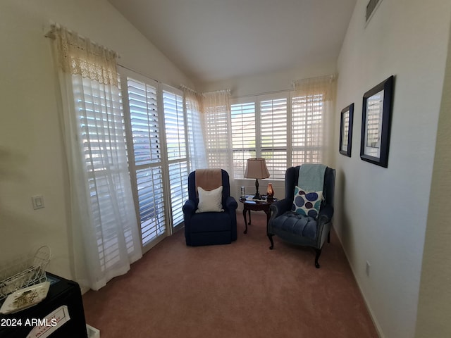 living area featuring carpet flooring and lofted ceiling