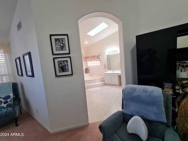 living area with light colored carpet, lofted ceiling with skylight, and sink