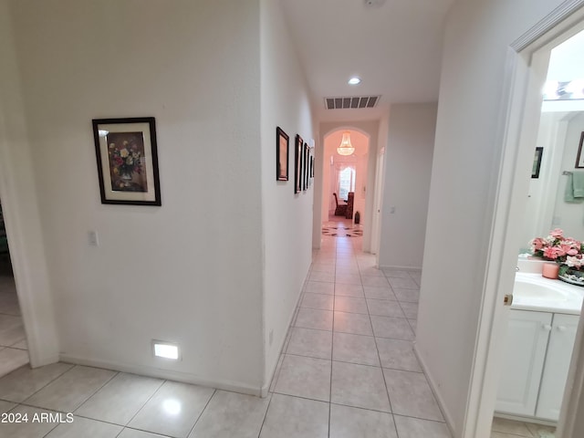 corridor with sink and light tile patterned floors