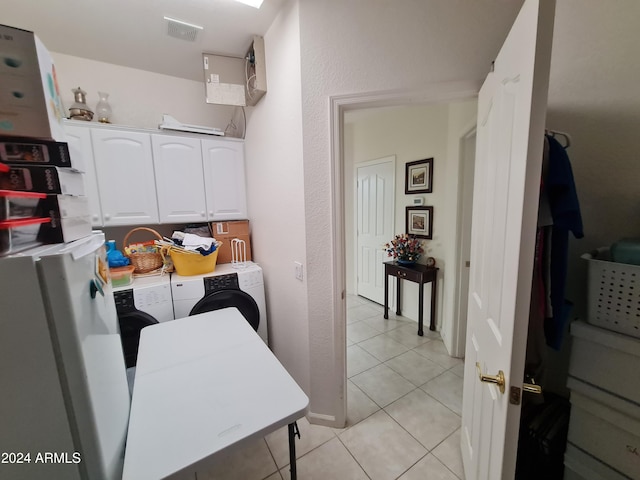 laundry room with light tile patterned flooring, cabinets, and separate washer and dryer