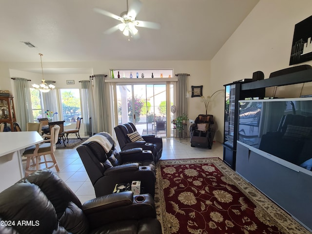 tiled living room featuring plenty of natural light, ceiling fan with notable chandelier, and vaulted ceiling