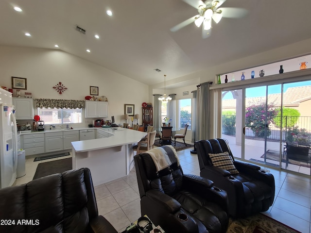 living room featuring ceiling fan with notable chandelier, lofted ceiling, sink, and light tile patterned floors