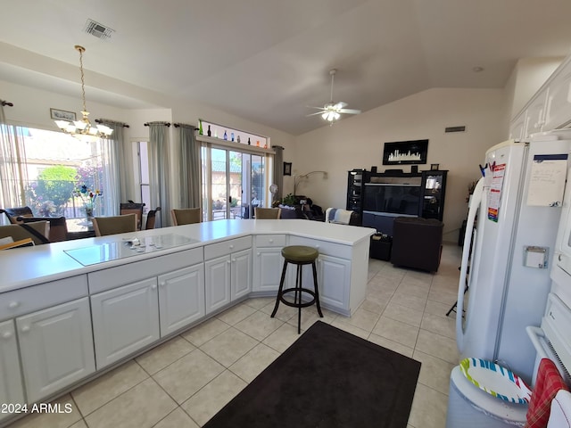 kitchen with lofted ceiling, ceiling fan with notable chandelier, white refrigerator, light tile patterned floors, and white cabinetry