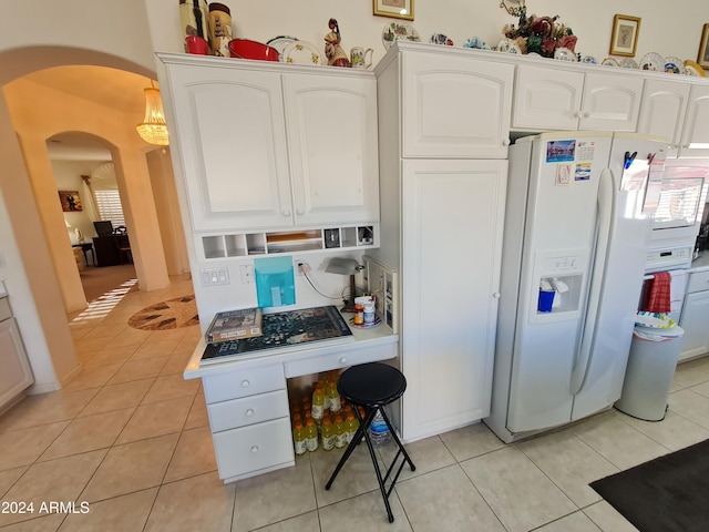 kitchen with white cabinetry, light tile patterned flooring, and white fridge with ice dispenser