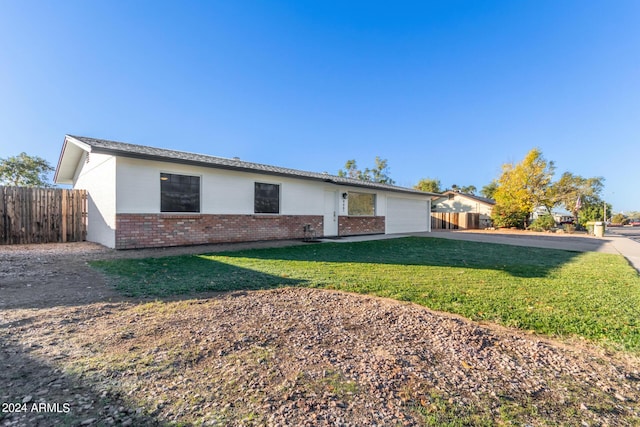 ranch-style home featuring a front yard and a garage