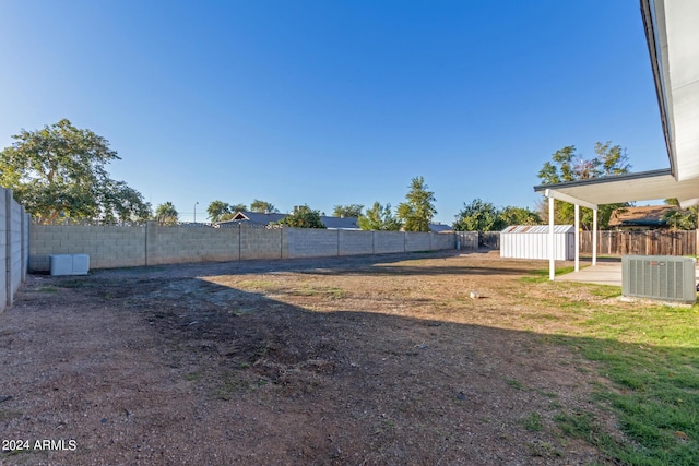 view of yard with a patio, cooling unit, and a storage shed