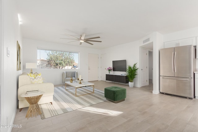 living room with ceiling fan and light hardwood / wood-style flooring