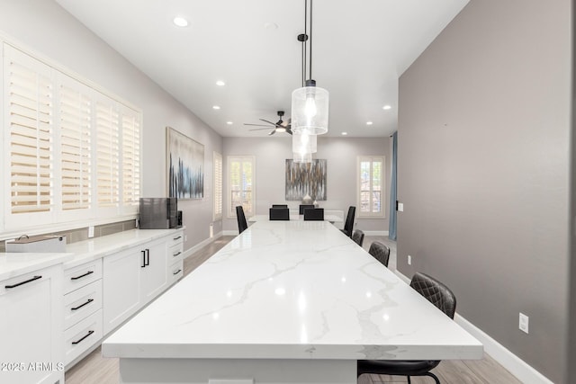 870 E Megan St, Gilbert, AZ 85295 - kitchen with a center island, a kitchen bar, ceiling fan, baseboards, and recessed lighting