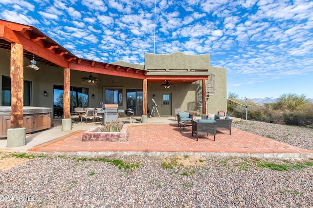 rear view of property with ceiling fan and a patio area