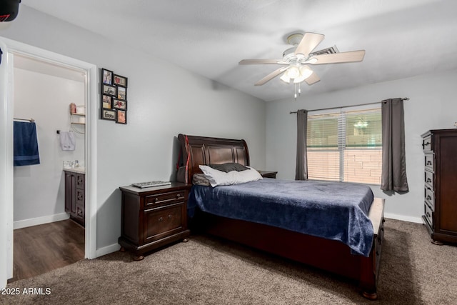 carpeted bedroom with ceiling fan, baseboards, and ensuite bath