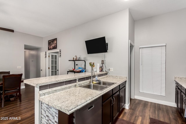 kitchen featuring dark wood-style floors, a peninsula, a sink, light countertops, and dishwasher