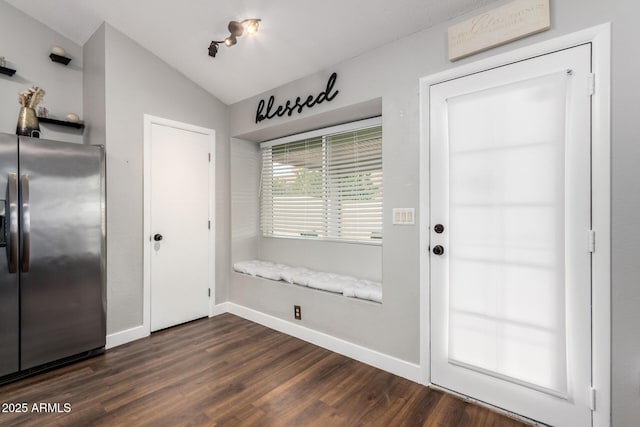 entryway with baseboards, dark wood-type flooring, and vaulted ceiling