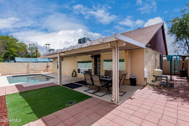 rear view of house featuring stucco siding, a lawn, a patio, a fenced backyard, and a fenced in pool