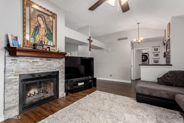 living room with stacked washer / drying machine, lofted ceiling, visible vents, and wood finished floors