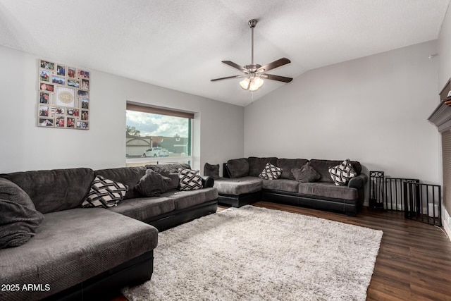 living room featuring dark wood finished floors, vaulted ceiling, a ceiling fan, and a textured ceiling