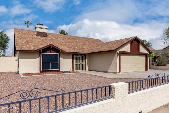 view of front facade with fence, driveway, a chimney, stucco siding, and a garage