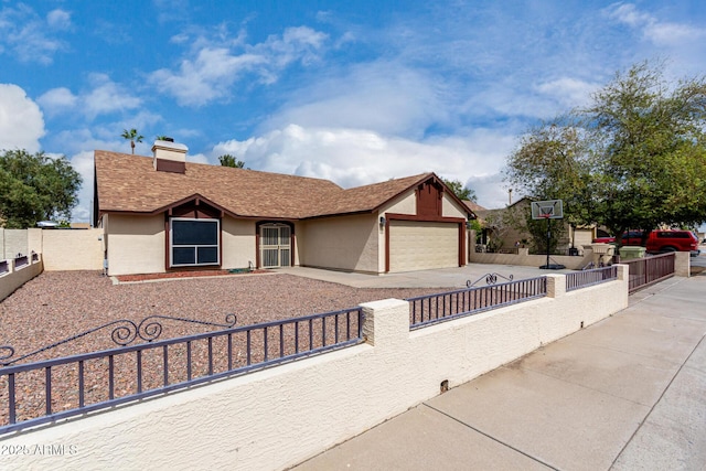 view of front facade with stucco siding, a fenced front yard, concrete driveway, a garage, and a chimney