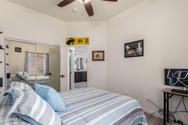 bedroom with baseboards, ceiling fan, wood finished floors, a closet, and a sink