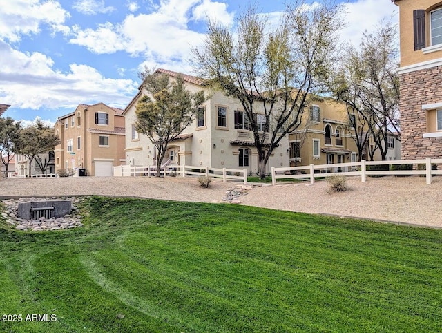 view of home's community featuring a residential view, a lawn, and fence