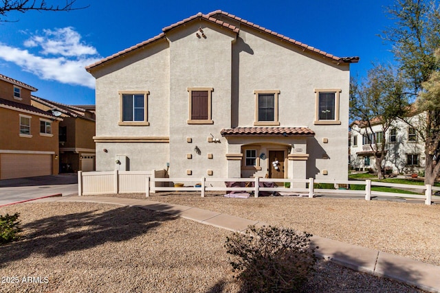 back of property featuring a fenced front yard, stucco siding, and a tile roof