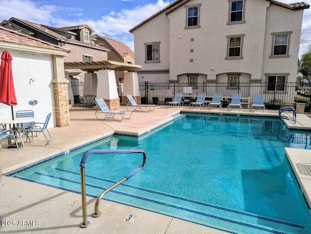 community pool with a pergola, a patio, and fence