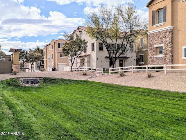 view of property's community with a lawn and fence