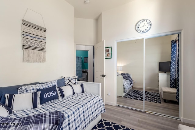 bedroom featuring a closet, baseboards, and wood finished floors