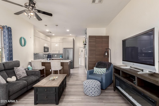 living room featuring recessed lighting, visible vents, light wood finished floors, and ceiling fan