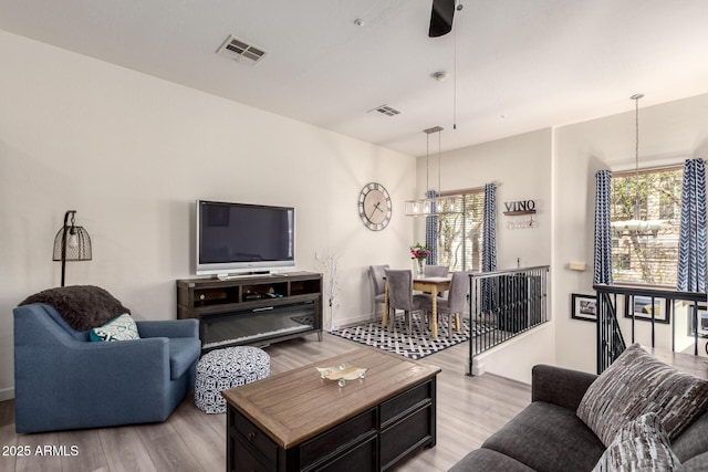 living room featuring a chandelier, visible vents, and light wood-style floors